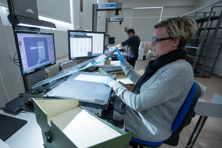 Employee scanning historical documents for the LONTAD project at UN Geneva Library and Archives.