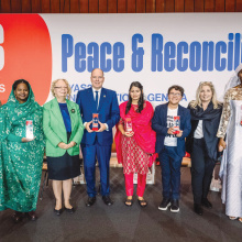 Young persons in front of a poster saying "peace and reconciliation"