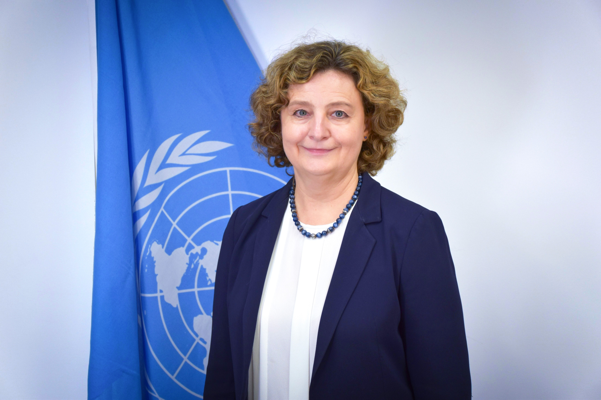 A portrait shot of Nataliya Myronenko in front of the UN flag