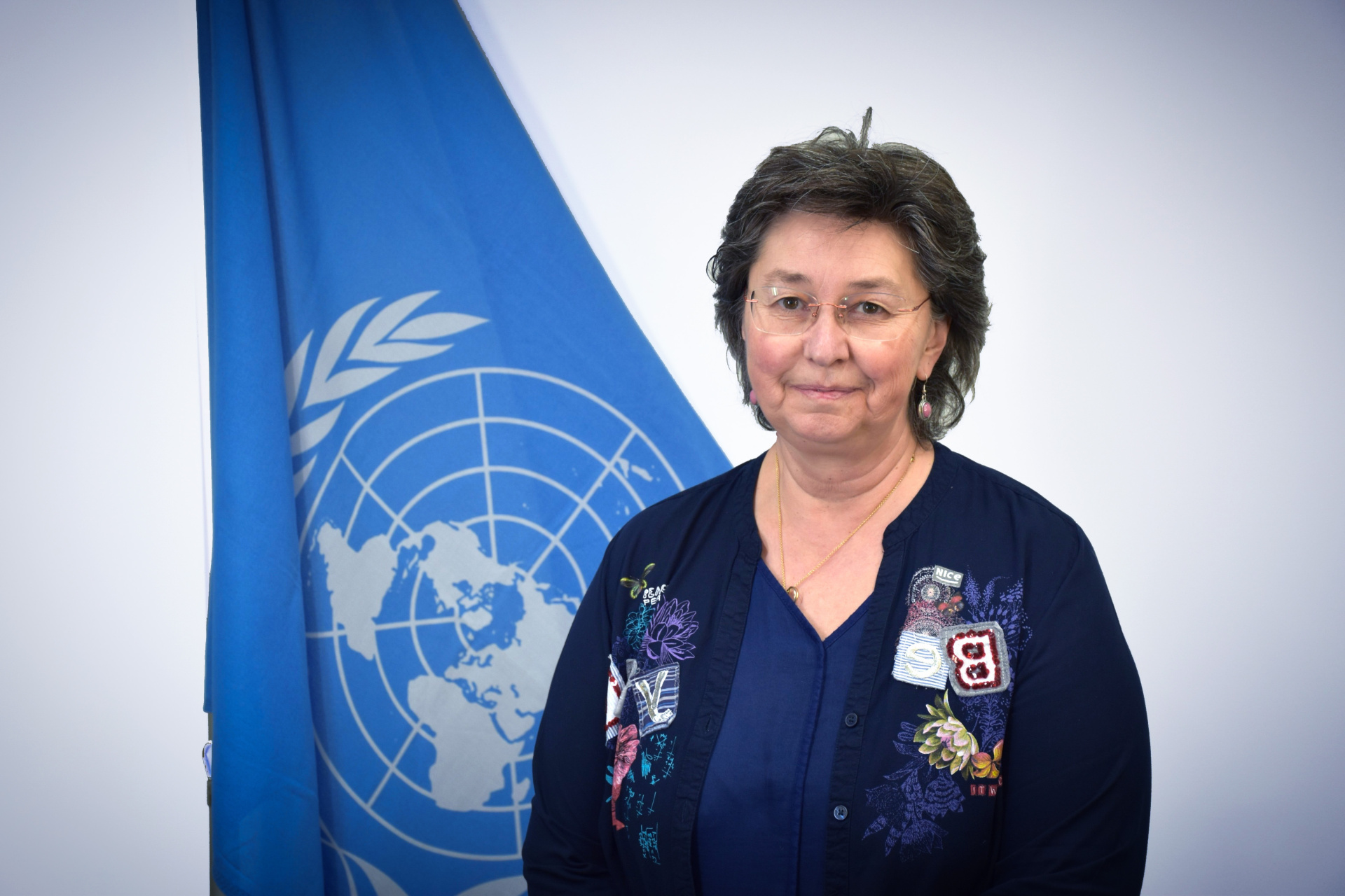 A portrait shot of Sophie Veaudour in front of the UN flag