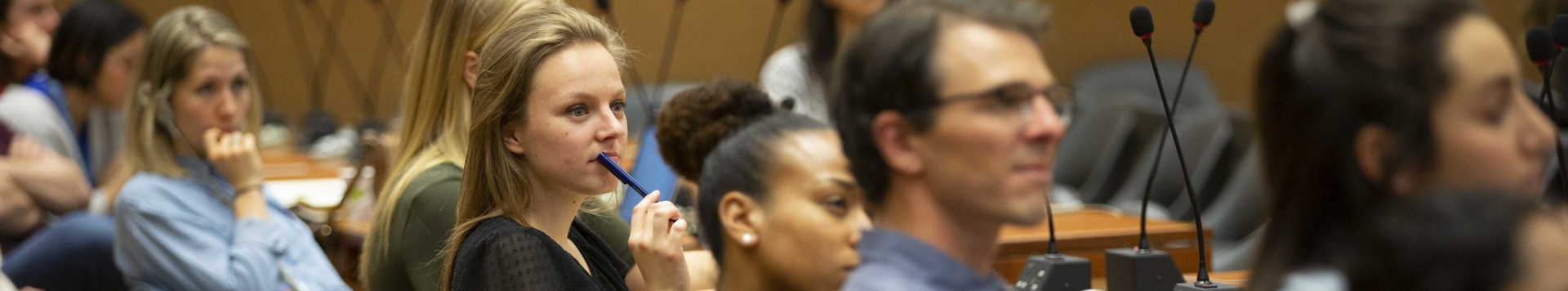 A group of conference participants listening attentively.